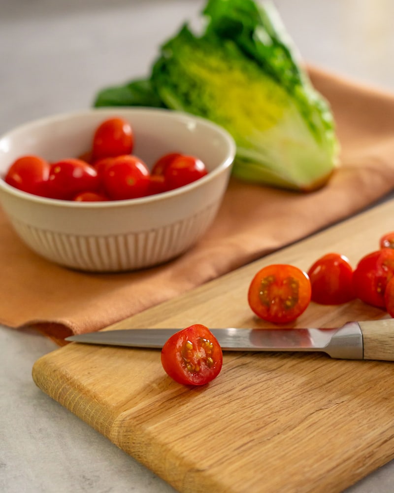 Dieses Bild zeigt wie die Cherrytomaten geschnitten werden.