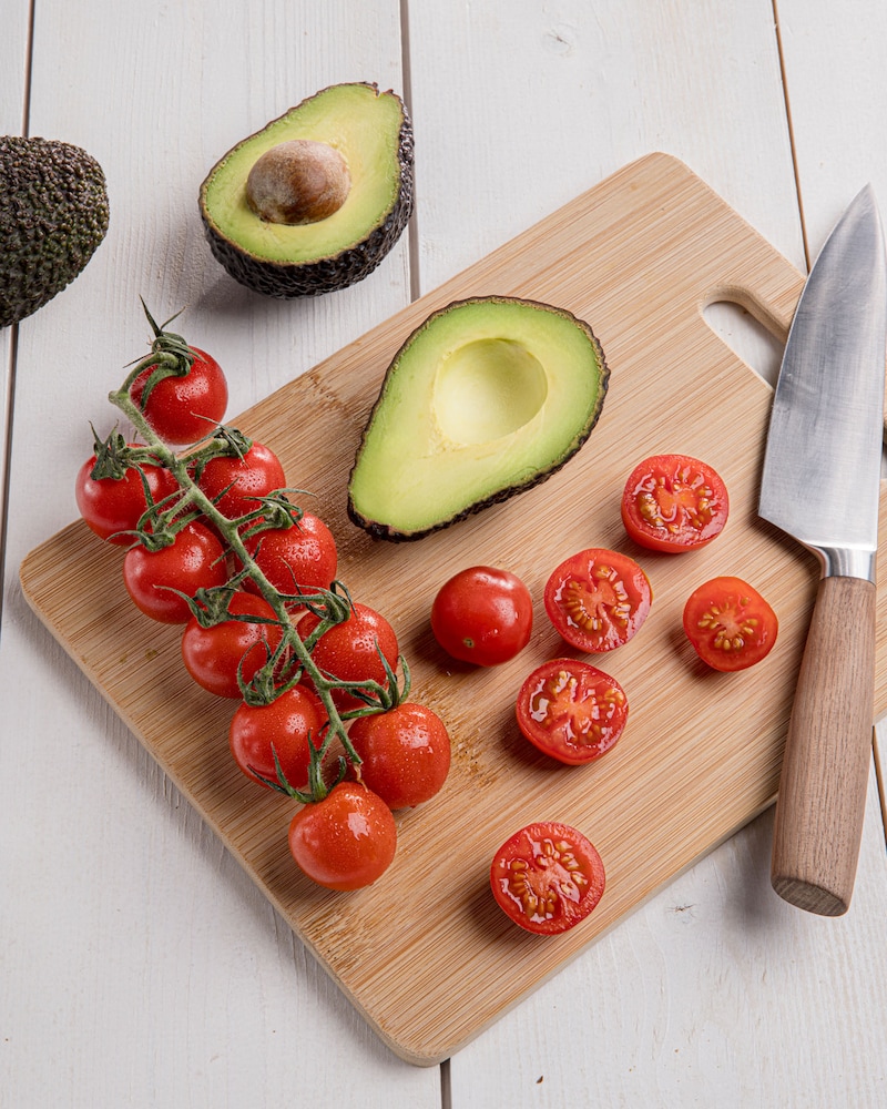 Dieses Bild zeigt eine halbierte Avocado und Tomaten.