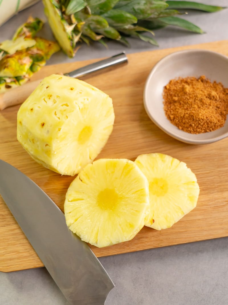 Dieses Bild zeigt wie die Ananas in Scheiben geschnitten wird.