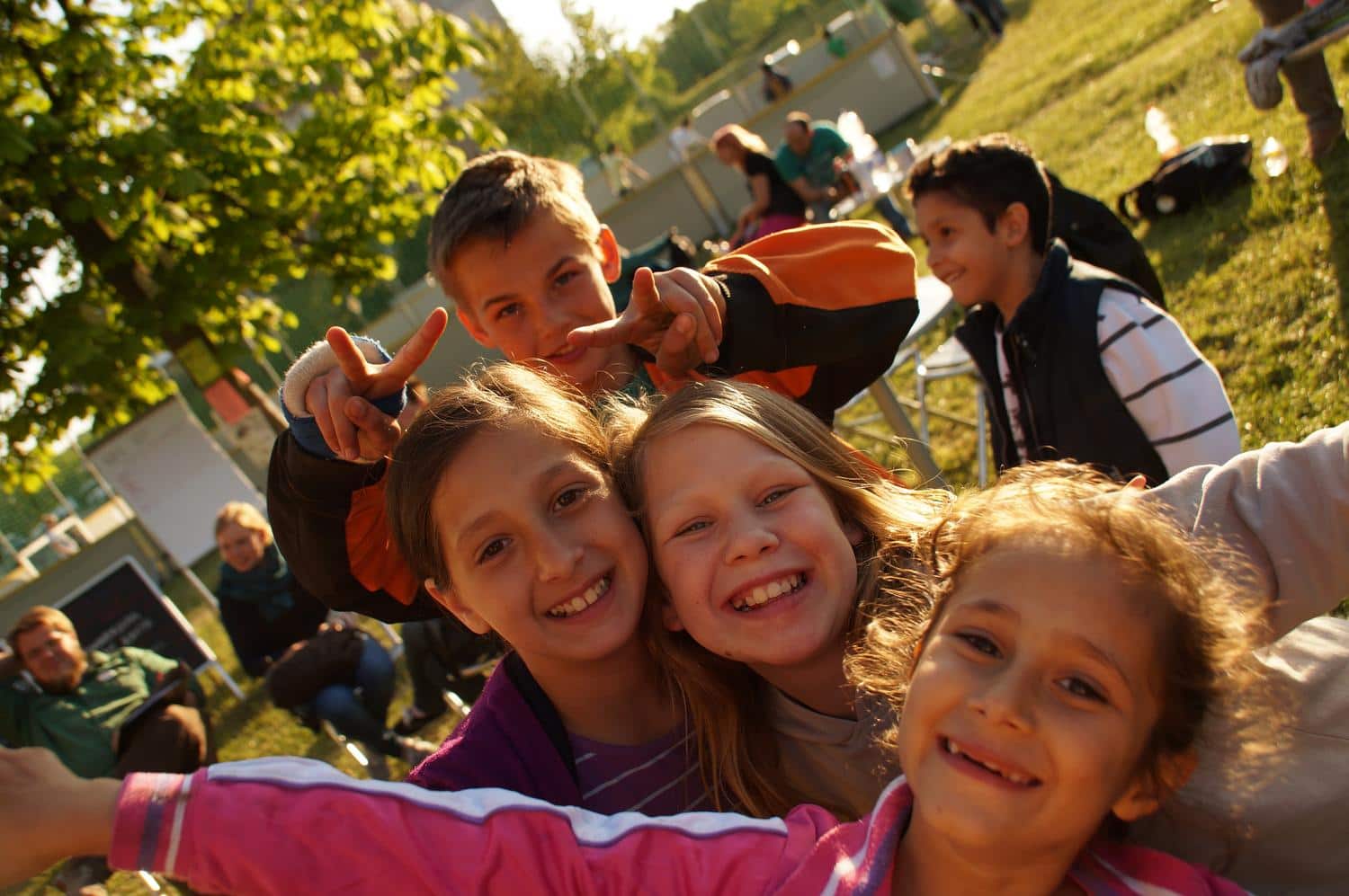 Kinder laecheln froehlich in die Kamera