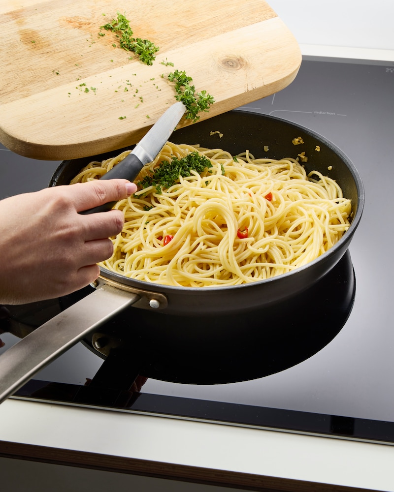 Dieses Bild das Nudelwasser zu den Spaghetti hinzugegeben wird.