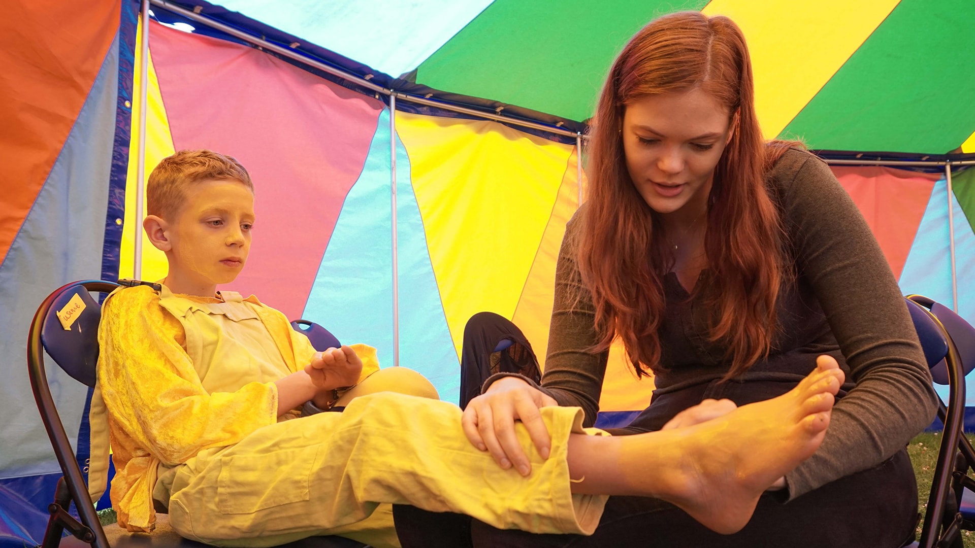 Kind mit Betreuerin in einem Zelt