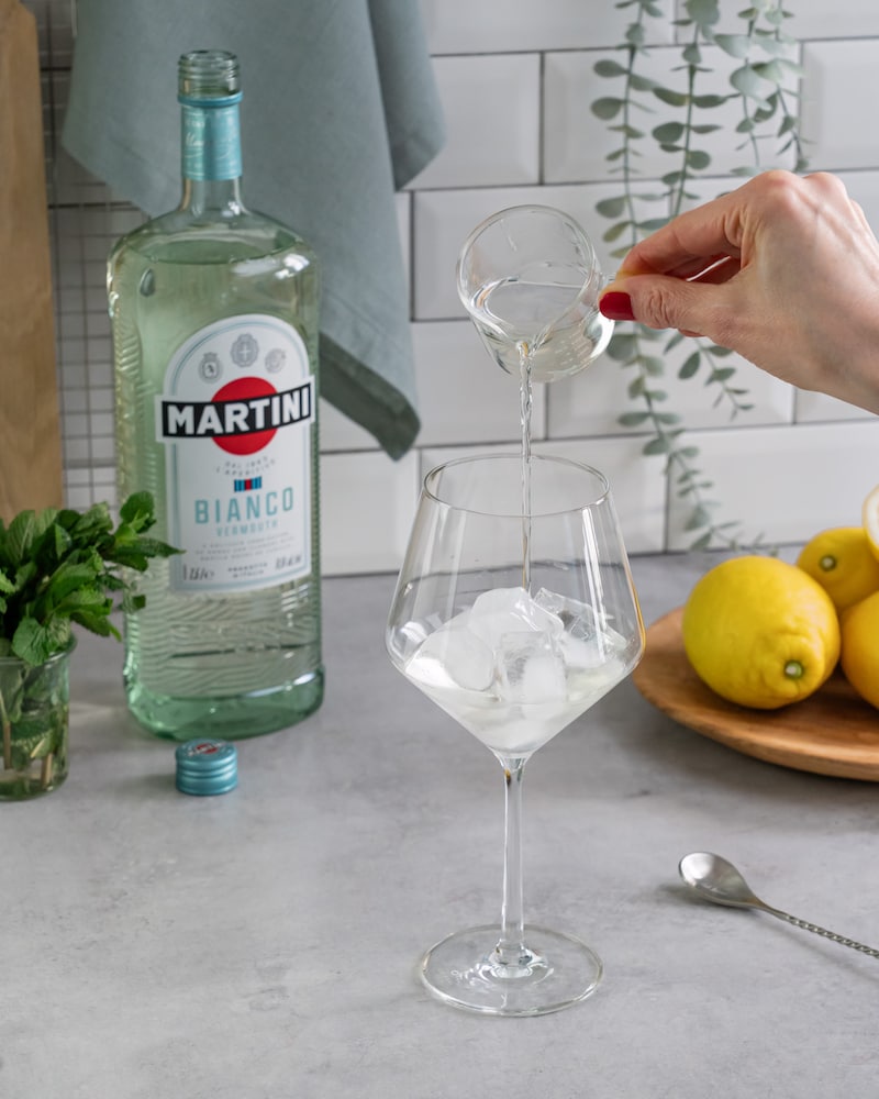 Diese Bild zeigt wie der Prosecco zum Martini gegeben wird.