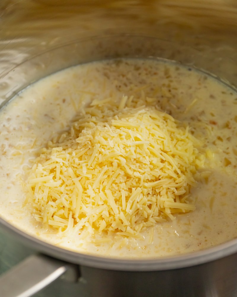 Dieses Bild zeigt das Hinzugeben des Käse in die Sahne Mischung. 