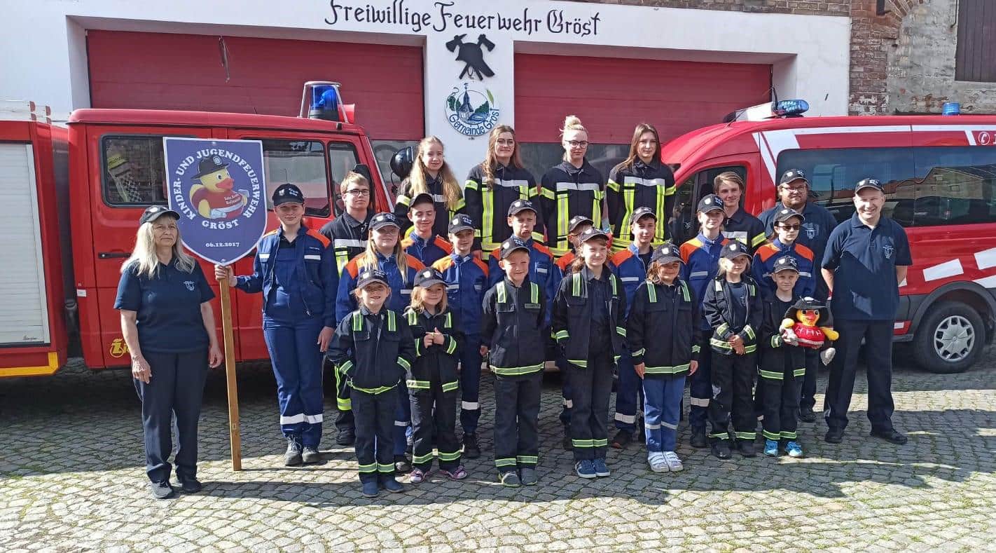 Kinder, Jugendliche und Vereinsmitglieder in Uniform laecheln in die Kamera