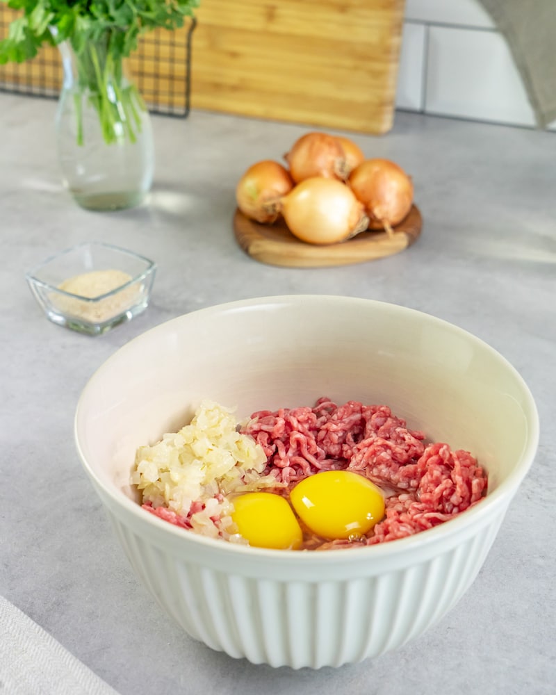 Das Bild zeigt das Hackfleisch mit den anderen Zutaten.