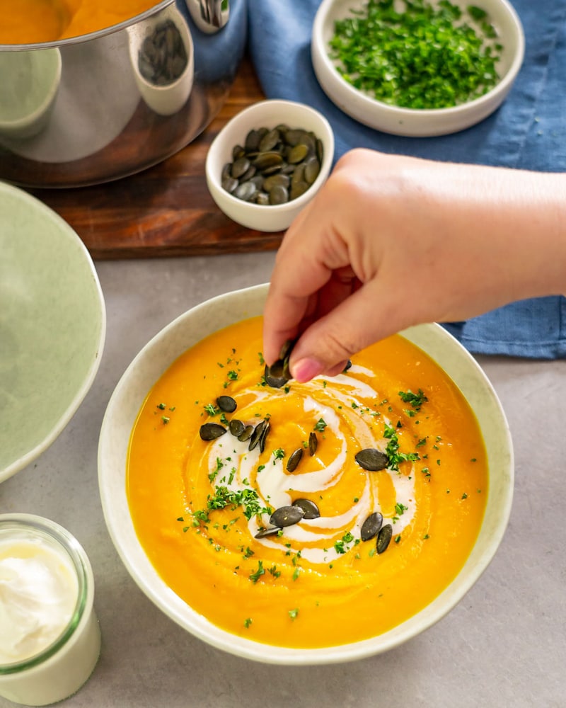 Dieses Bild zeigt wie die Petersilie über die Suppe gegeben wird.