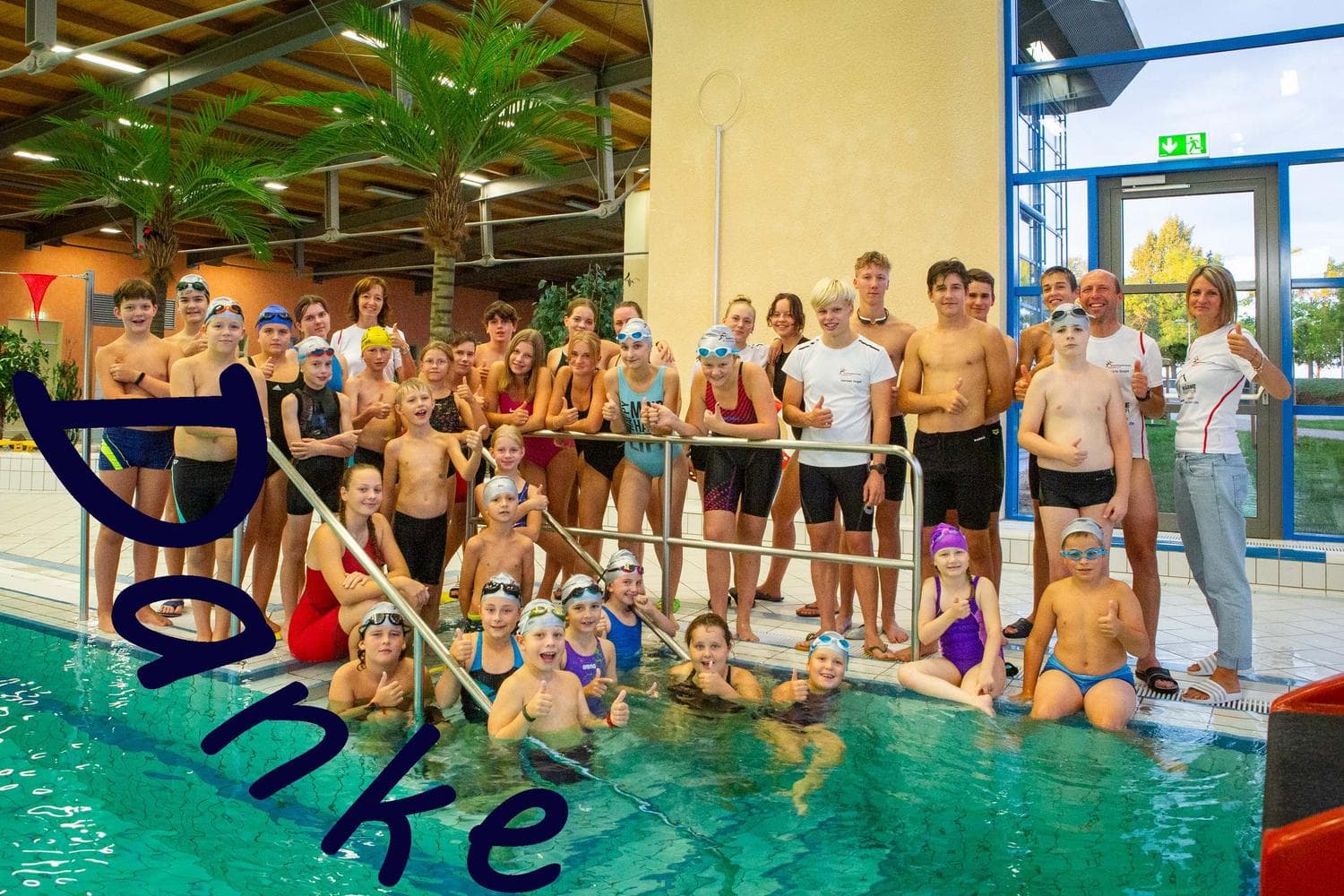 Kinder und Jugendliche im Schwimmbad laecheln in die Kamera