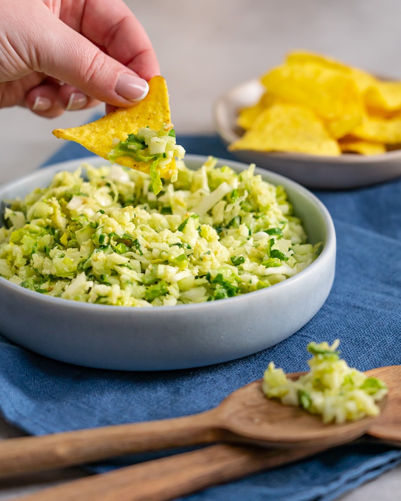 Dieses Bild zeigt wie der Salat mit einem Nacho gegessen wird.