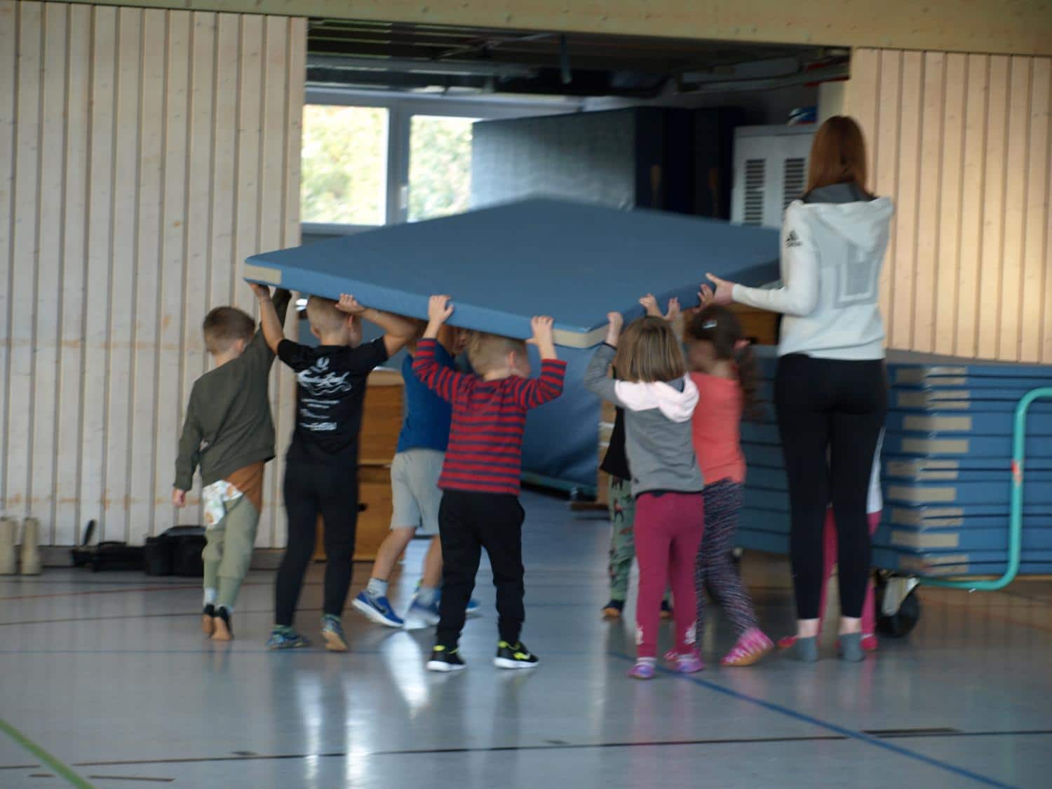 Kinder rauemen Matten auf einen Mattenwagen