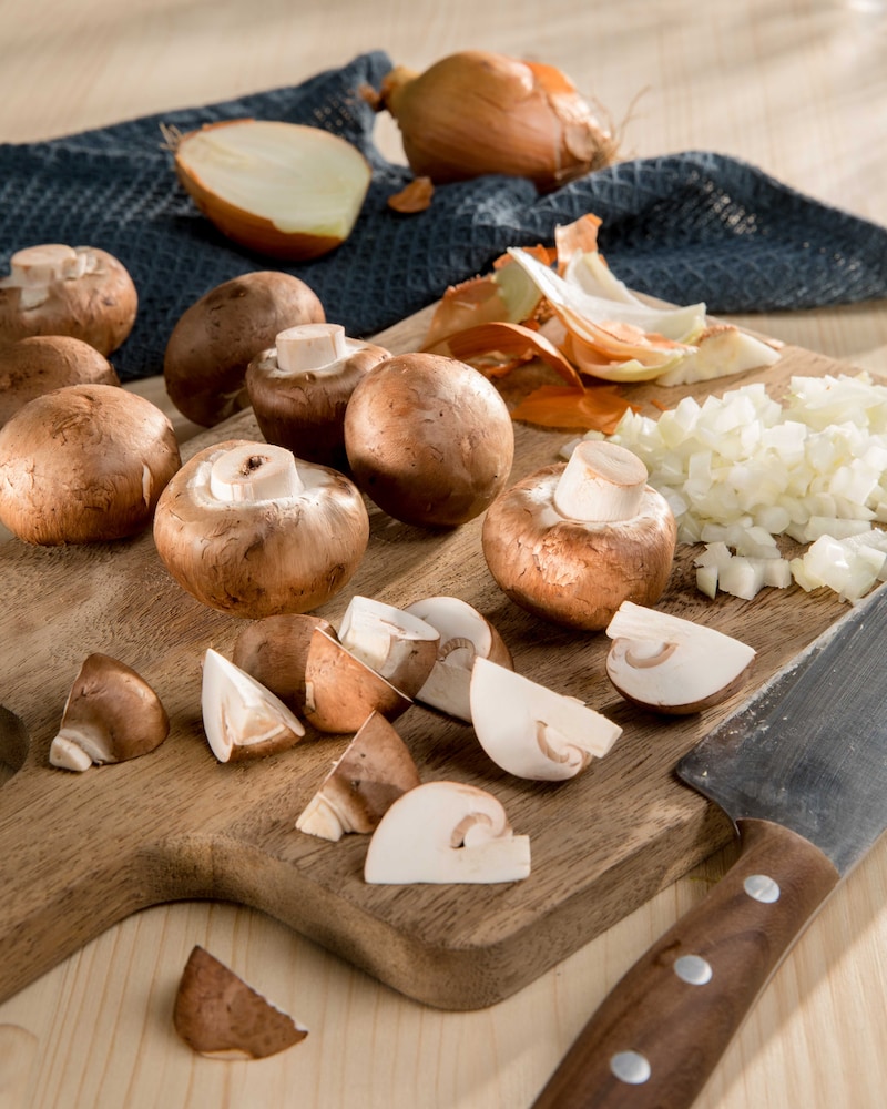 Auf diesem Bild siehst du geschnittene Pilze und Zwiebeln.