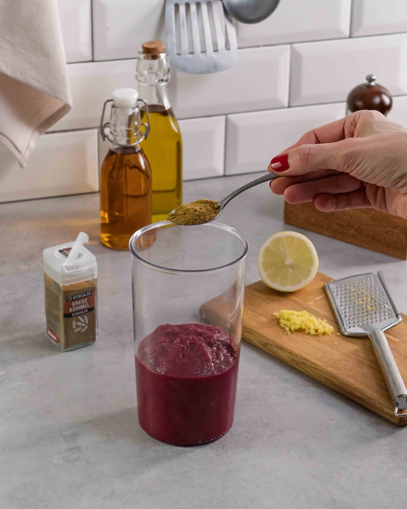 Dieses Bild zeigt wie der Hummus gewürzt wird.