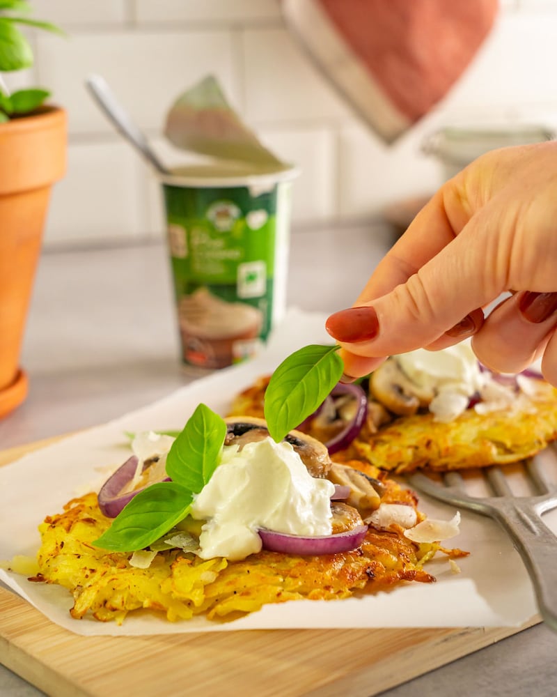 Dieses Bild zeigt wie der Basilikum auf den Kartoffelrösti gegeben wird.