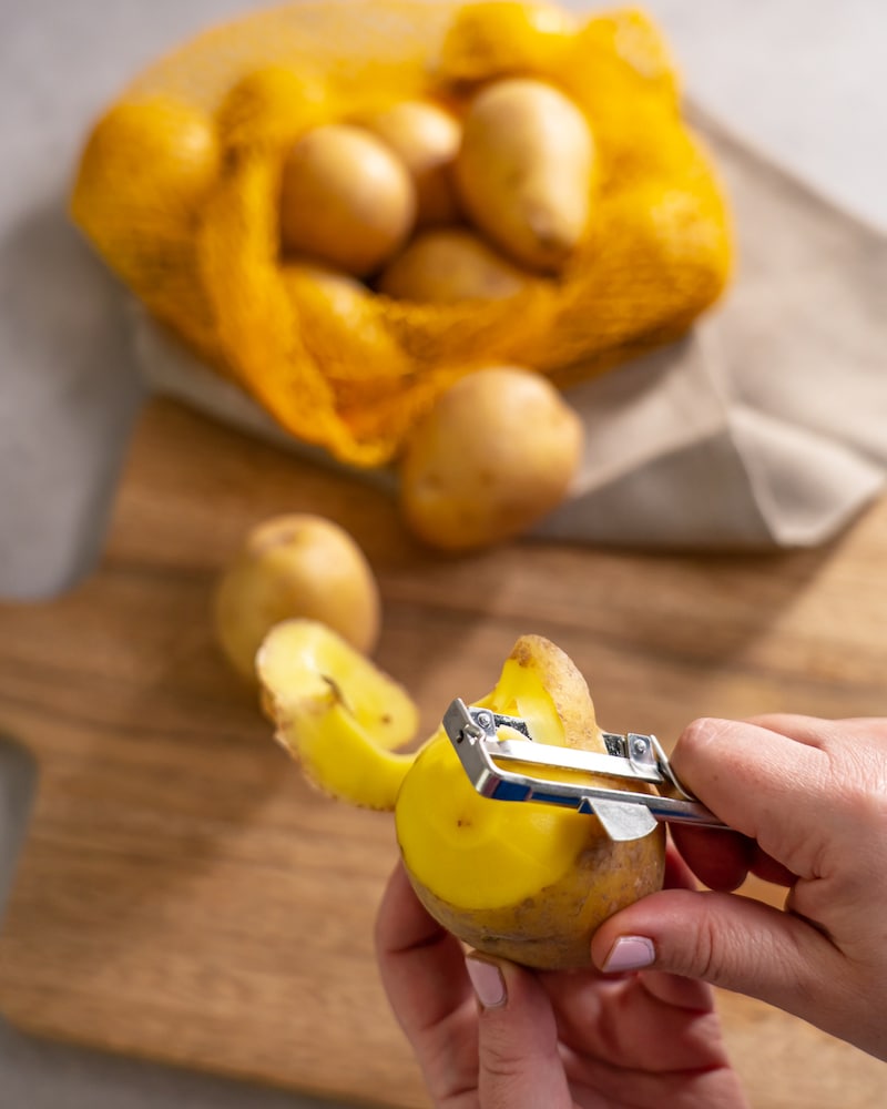 Dieses Bild zeigt wie Kartoffeln geschält werden.