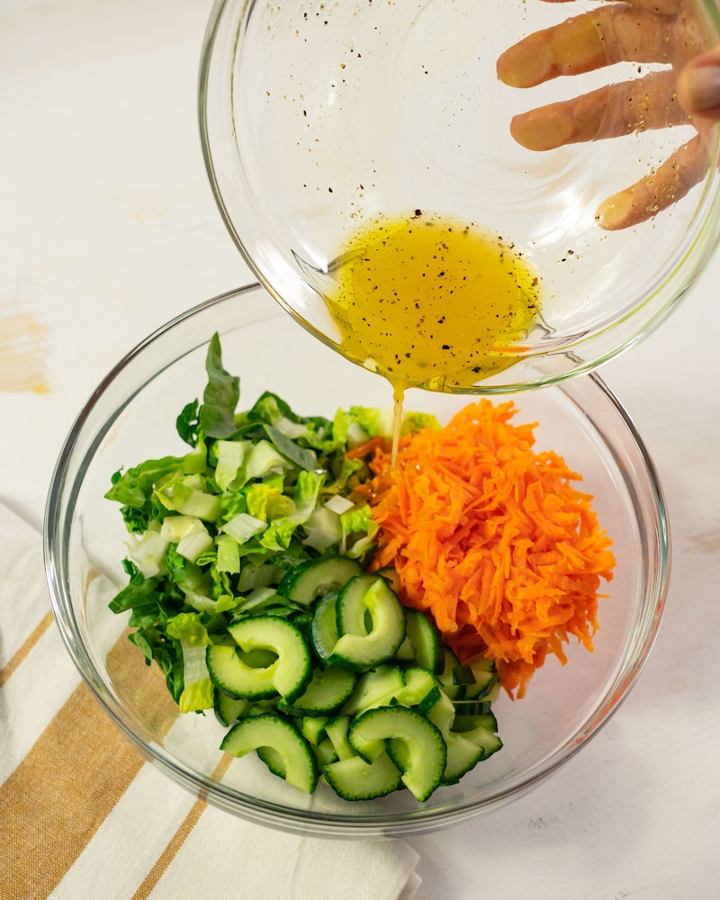 Dieses Bild zeigt wie der Salat mit dem Dressing vermengt wird.