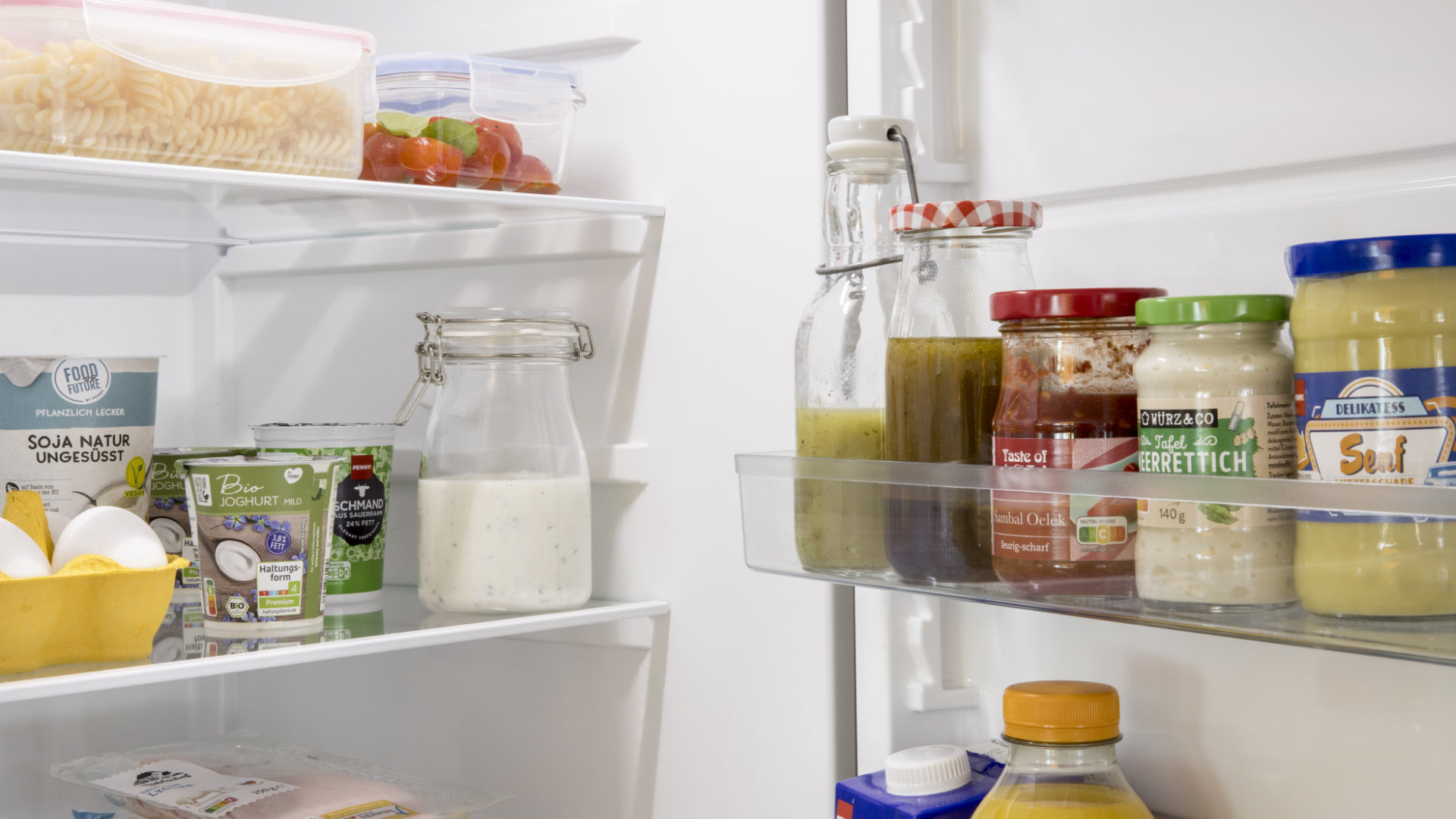 Blick in offenen Kühlschrank, in dem unterschiedlich Dressings stehen.