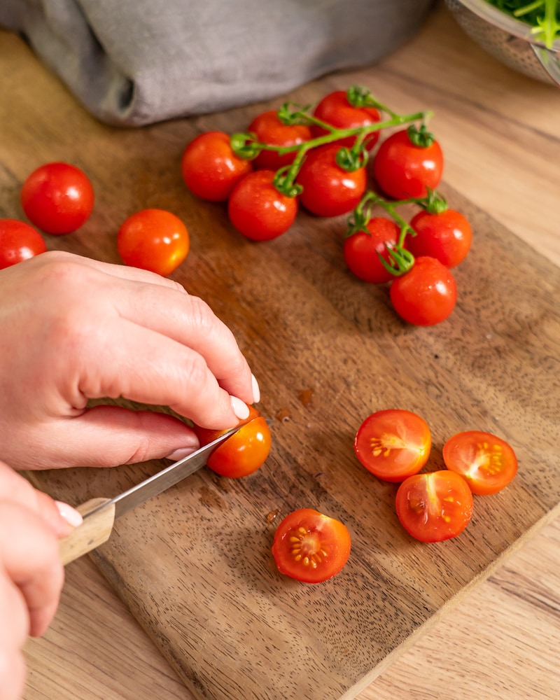 Dieses Bild zeigt, wie Tomaten halbiert werden.