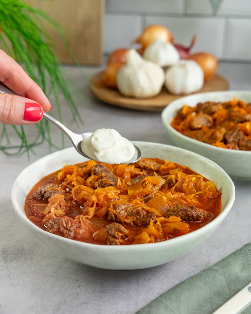 Auf diesem Bild siehst du wie das Gulasch mit Schmand angerichtet wird.