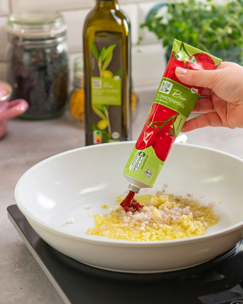 Dieses Bild zeigt den Knoblauch in der Pfanne mit Tomatenmark.