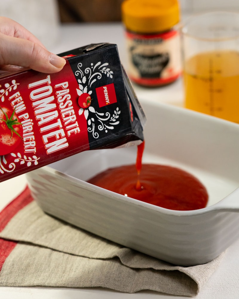 Dieses Bild zeigt wie passierte Tomaten dazugegeben werden.