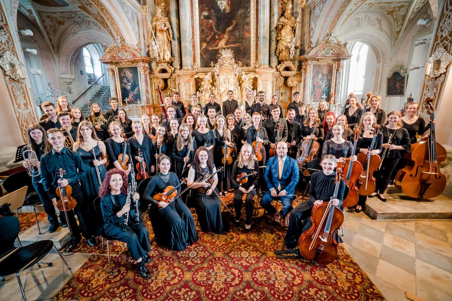 Vereinsmitglieder laecheln mit ihren Instrumenten in die Kamera