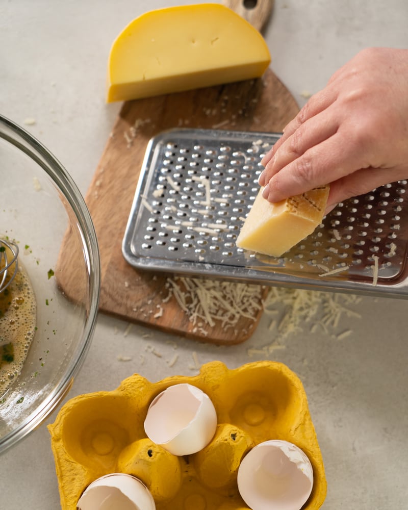 Auf diesem Bild siehst du wie Käse gerieben wird.
