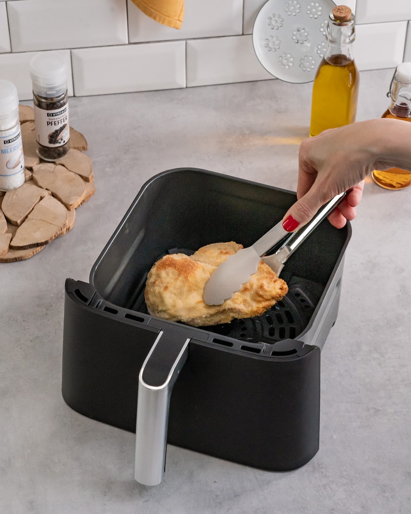 Dieses Bild zeigt wie das Cordon Bleu in die Heißluftfritteuse gegeben wird.