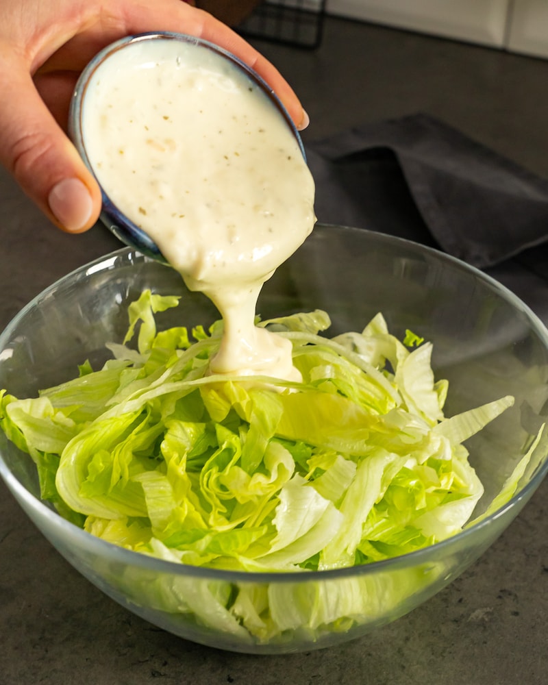Dieses Bild zeigt wie die Sauce über den Salat gegeben wird.