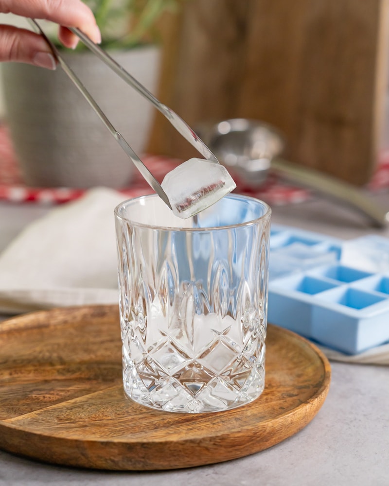 Dieses Bild zeigt wie Eiswürfel in ein Glas gegeben werden.