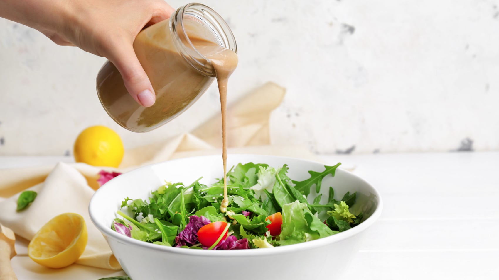Dressing über Salat gießen