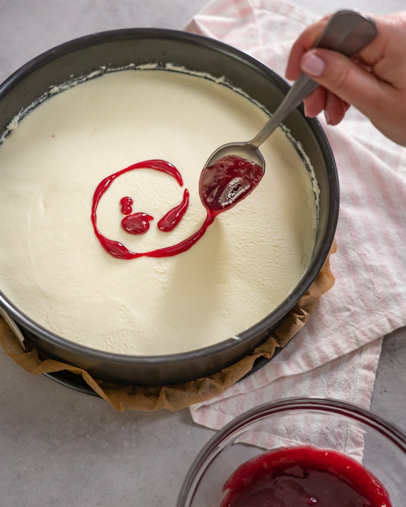 Dieses Bild zeigt wie Marmelade auf den Kuchen gegeben wird.