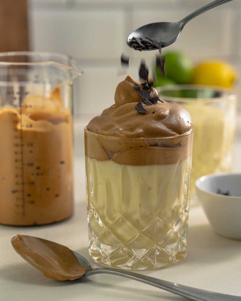 Auf diesem Bild siehst du wie die Kaffeecreme mit Schokoflakes garniert wird.