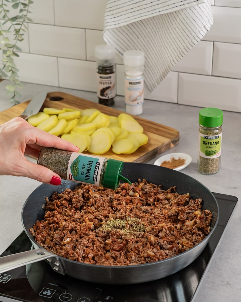 Auf diesem Bild siehst du wie das Hackfleisch gewürzt wird.