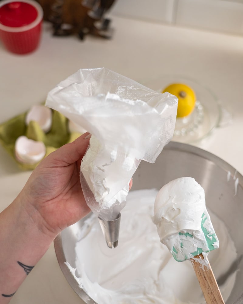 Dieses Bild zeigt wie der Eischnee in einen Spritzbeutel gegeben wird.