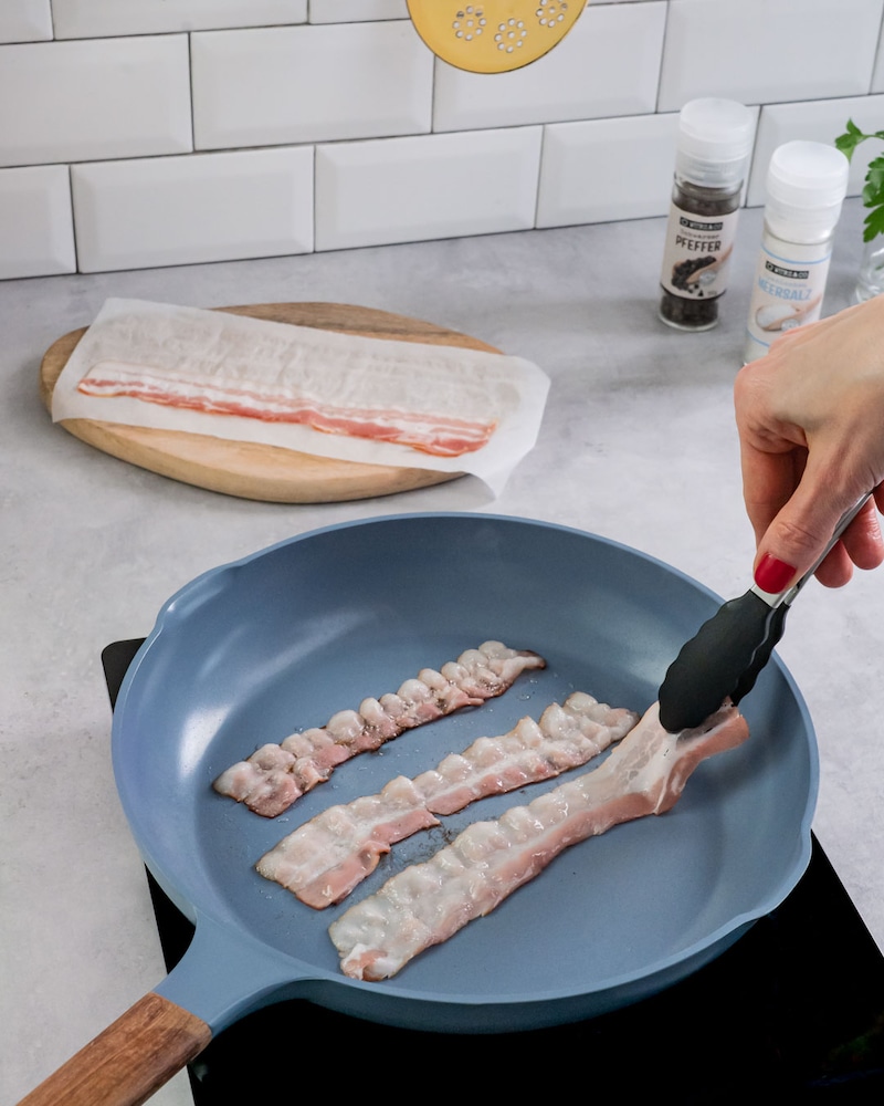 Dieses Bild zeigt, wie Speck angebraten wird.
