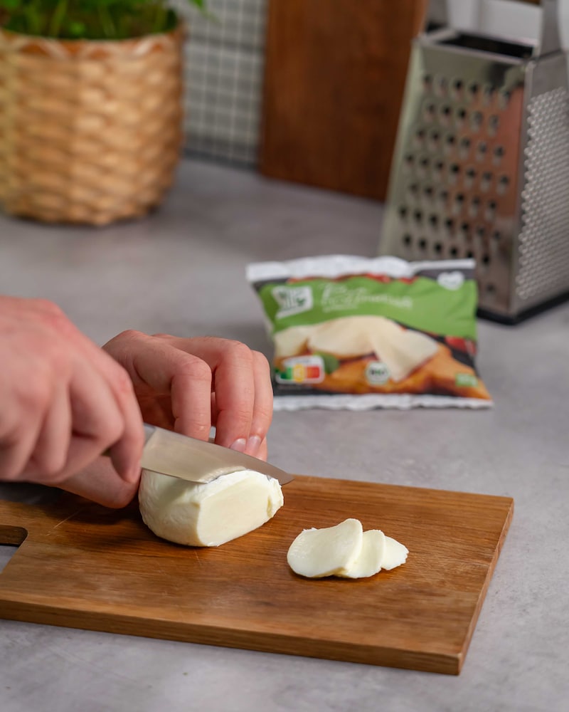 Dieses Bild zeigt, wie der Mozzarella geschnitten wird.