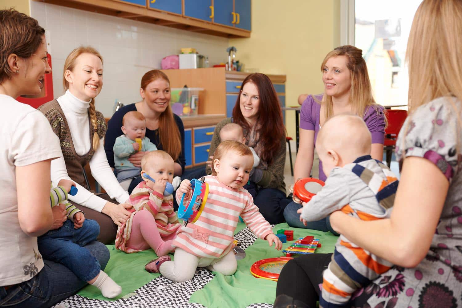 Vereinsmitglieder mit Babys beim Spielen