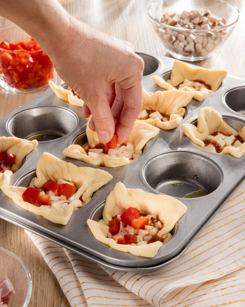 Dieses Bild zeigt wie die Pizzamuffins gefüllt werden.