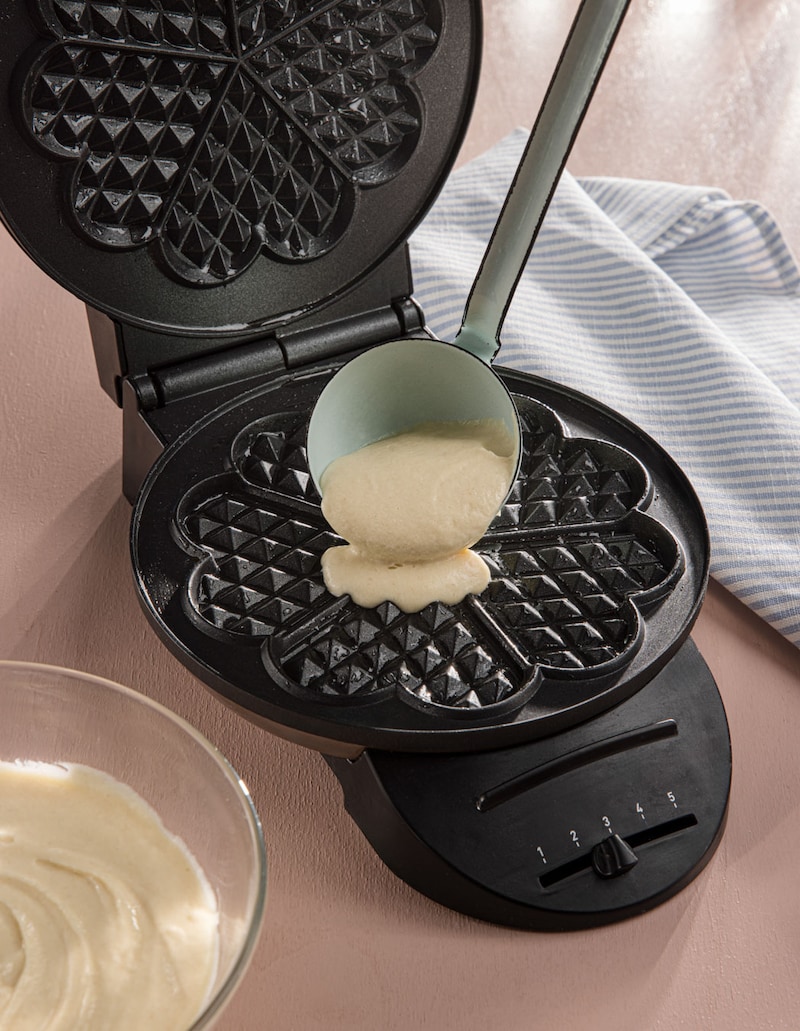 Dieses Bild zeigt wie der Waffelteig in das Waffeleisen gegeben wird.