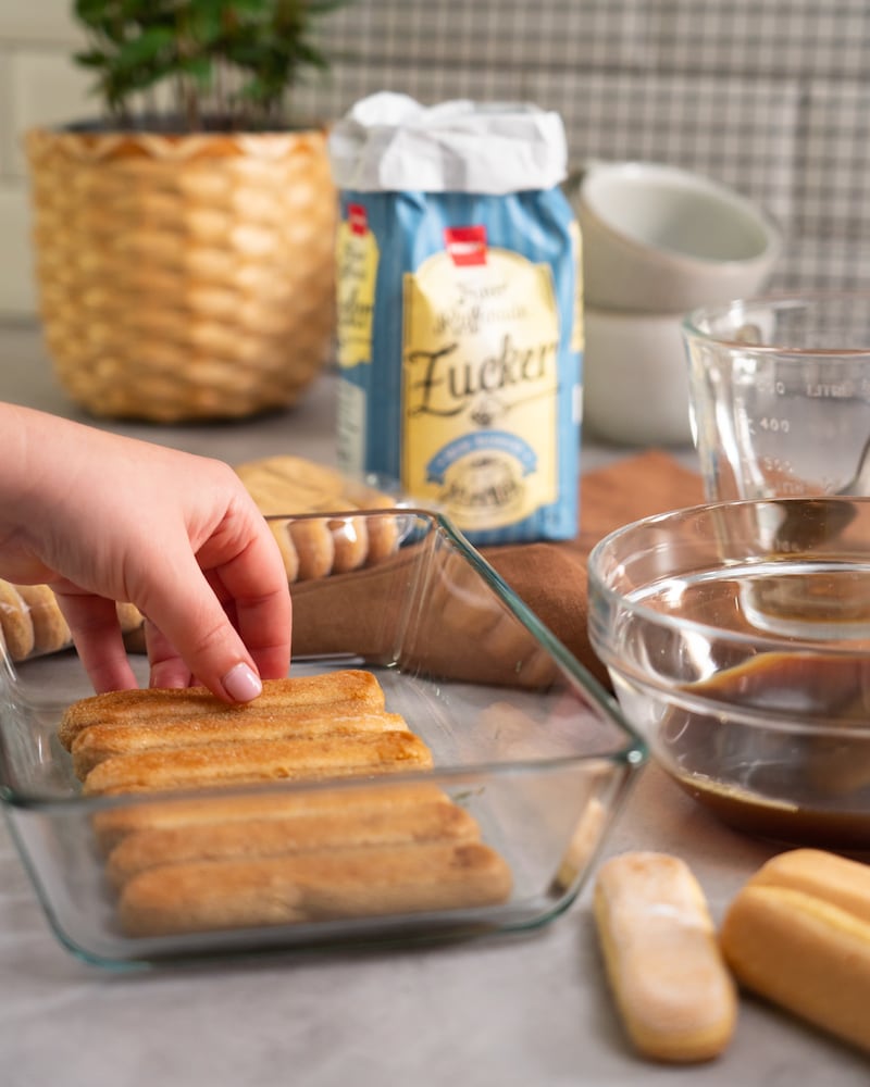 Dieses Bild zeigt wie Löffelbisquits in eine Form gegeben werden.