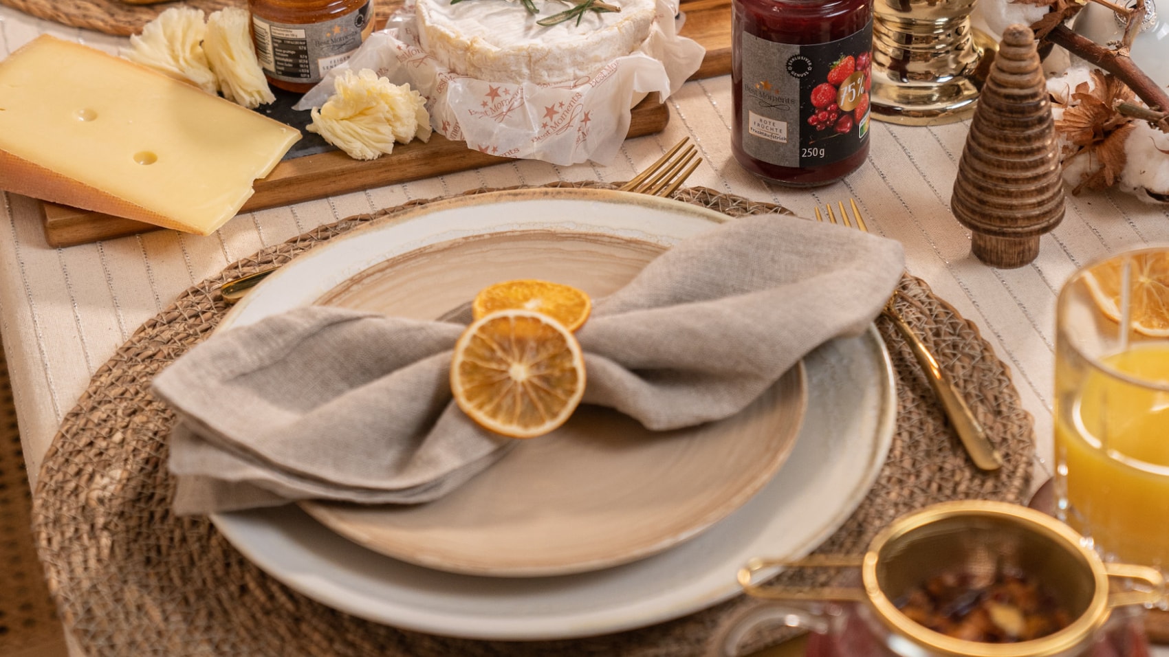 Serviette mit Deko aus Orangenscheiben auf einem festlich gedeckten Tisch.