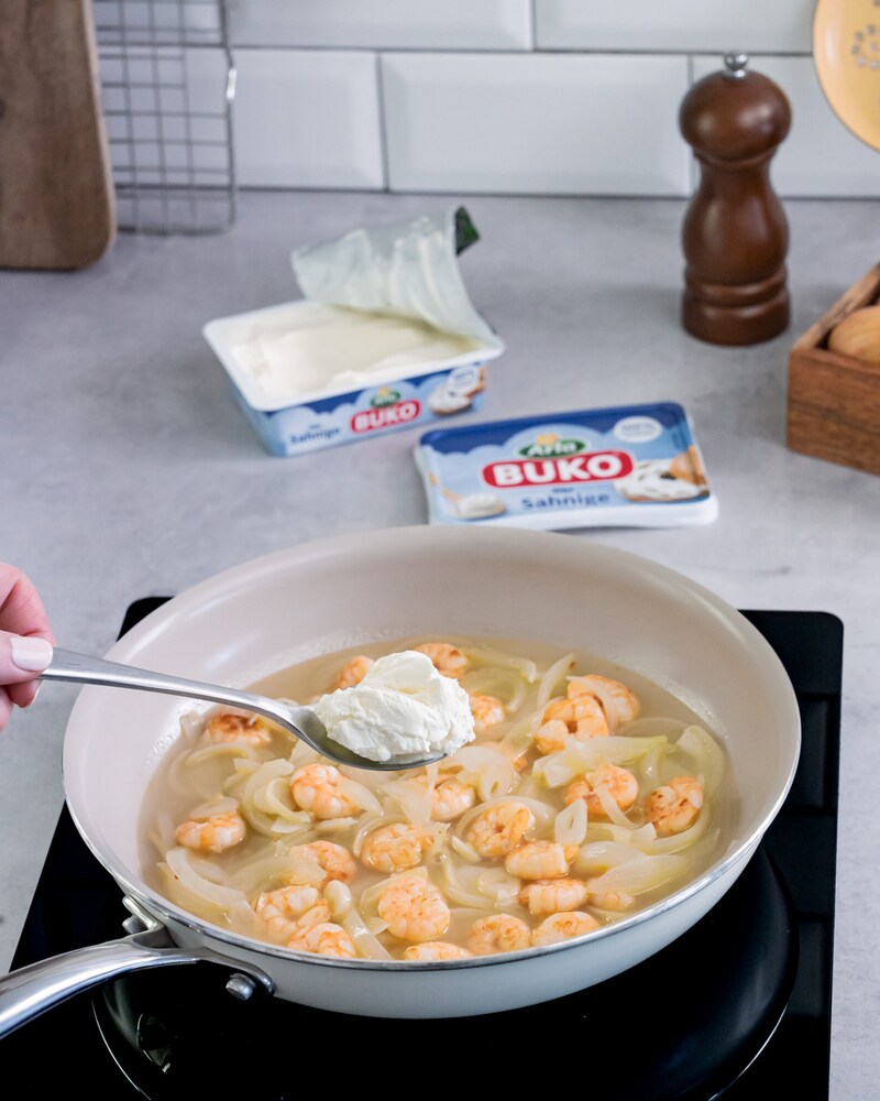 Dieses Bild zeigt wie der Frischkäse zu den Garnelen gegeben werden.