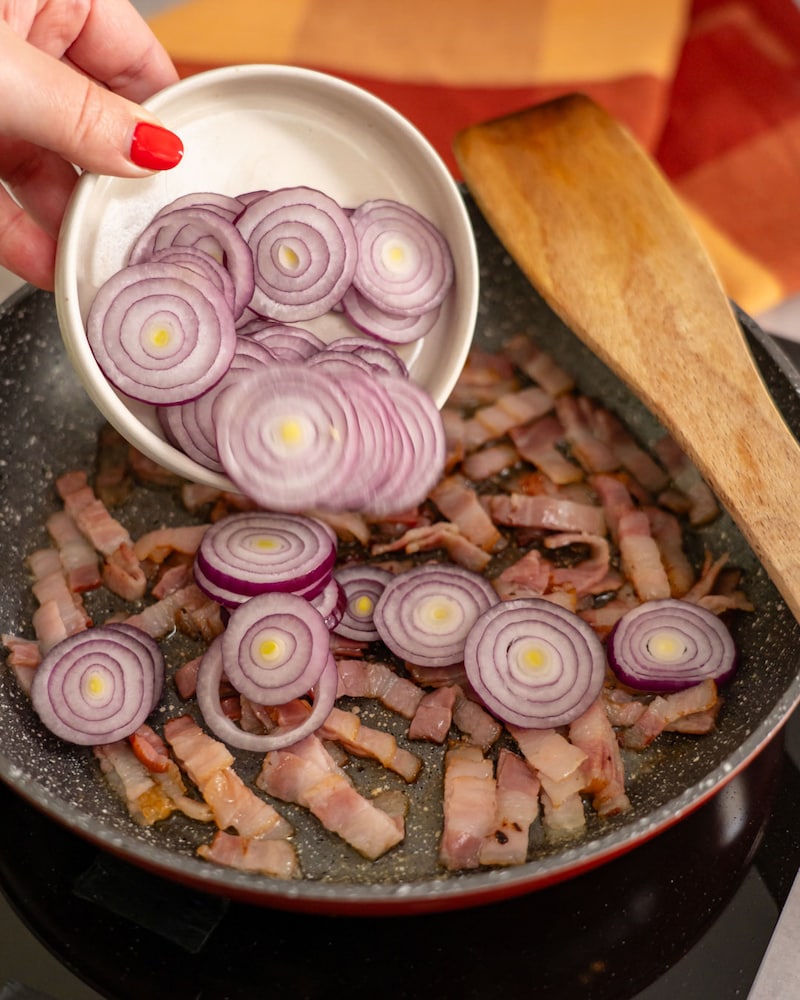Dieses Bild zeigt die Zwiebeln und den Bacon in der Pfanne.