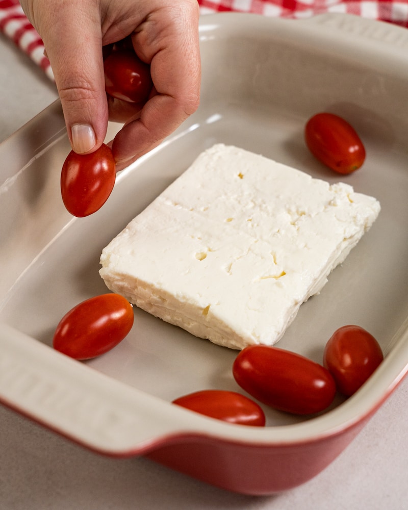 Auf diesem Bild siehst du wie Kirschtomaten in eine Auflaufform gegeben werden.