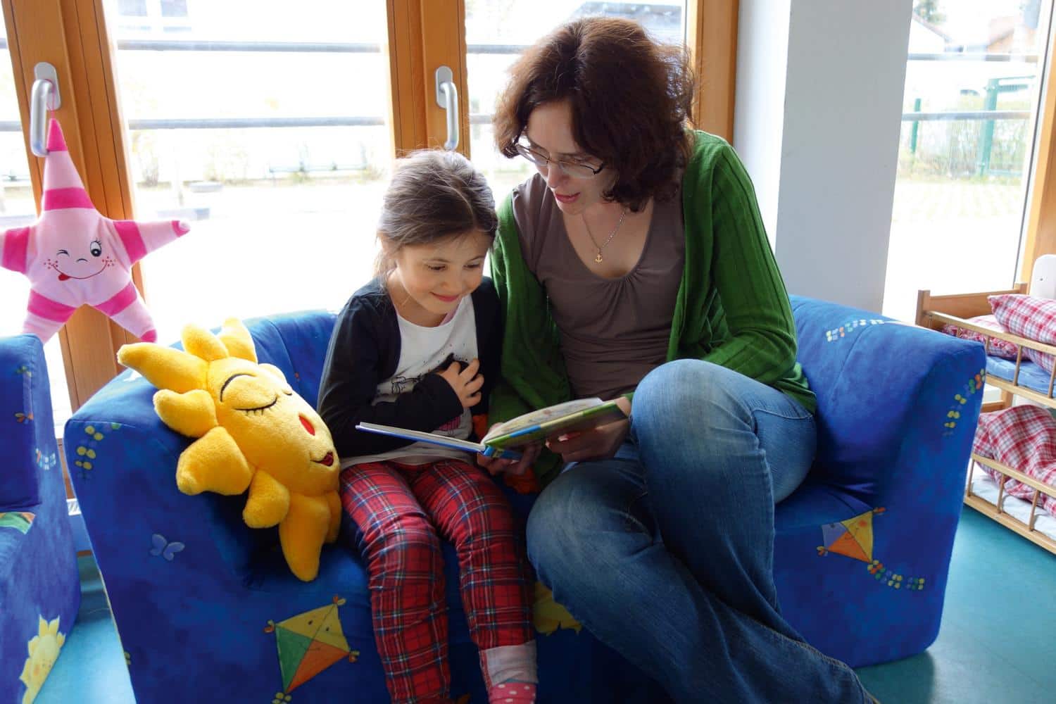 Eine Frau liest einem Kind aus einem Buch vor