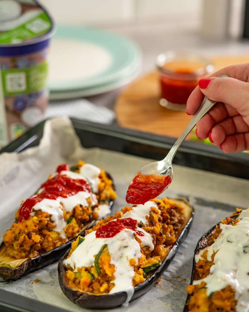 Dieses Bild zeigt wie der Joghurt und das Chili auf die Auberginen gegeben werden.