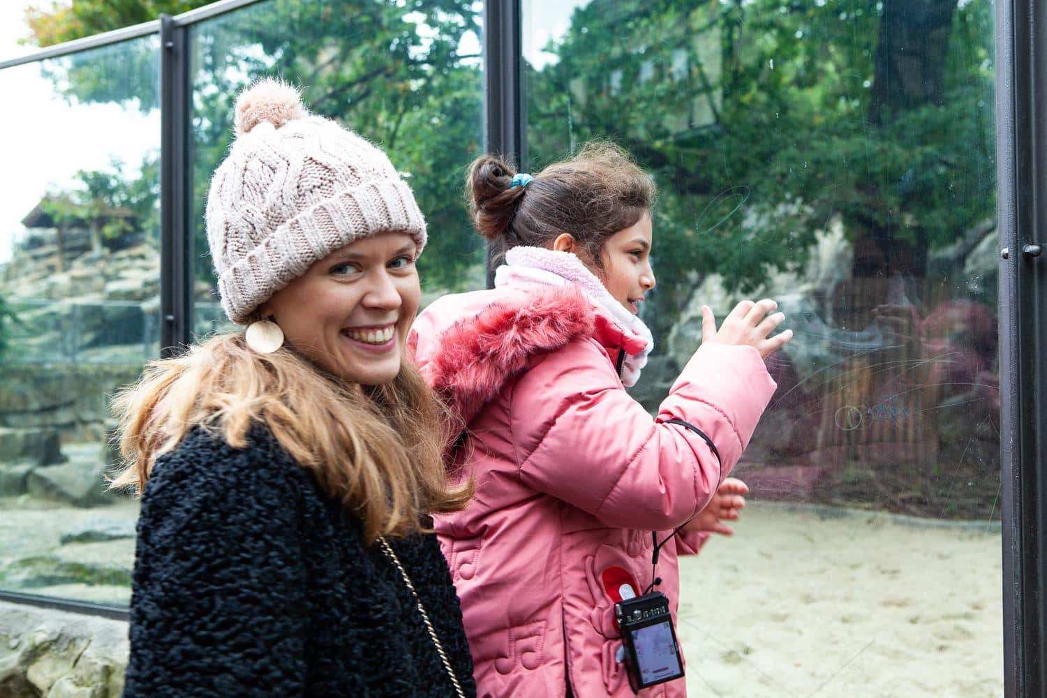Eine Frau und ein Kind beobachten Tiere im Zoo