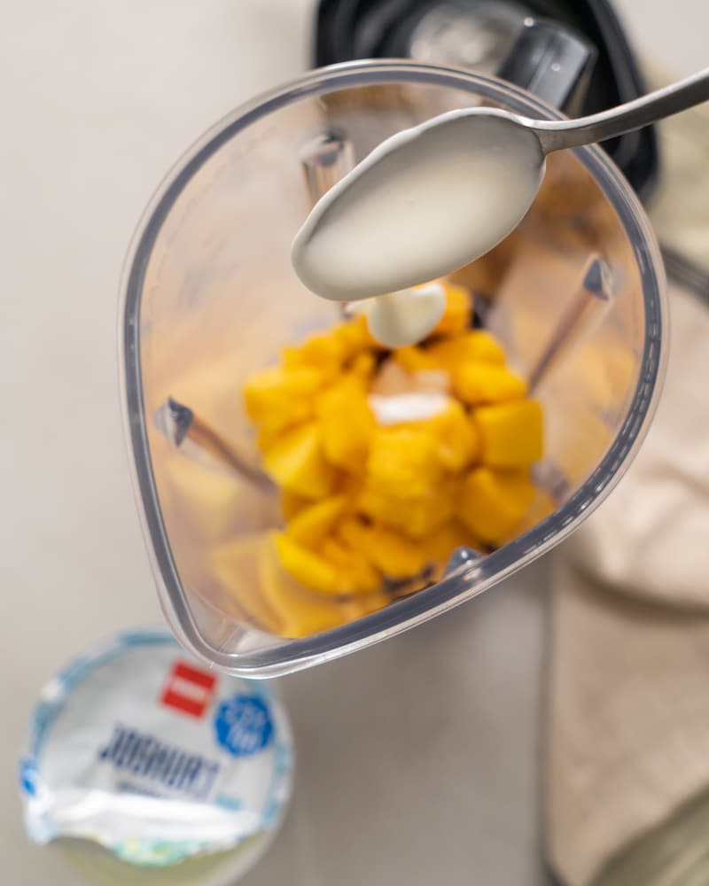 Auf diesem Bild siehst du wie Joghurt in den Mixer gegeben wird.
