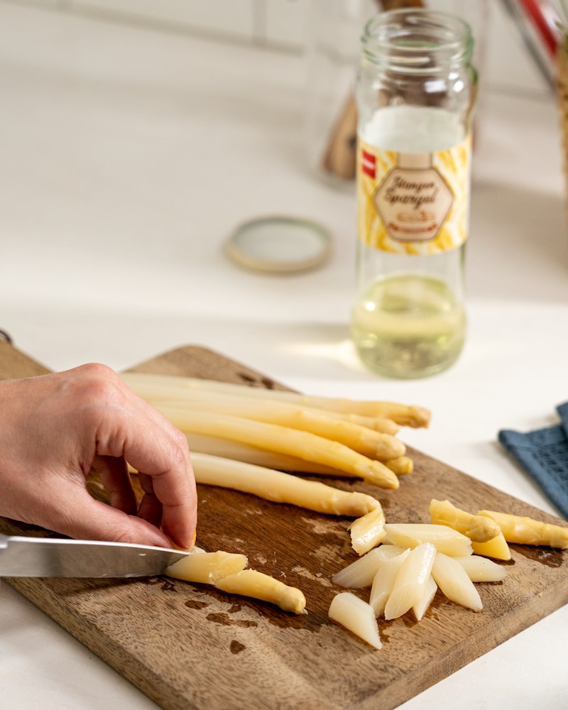 Auf diesem Bild siehst du wie Spargel geschnitten wird.