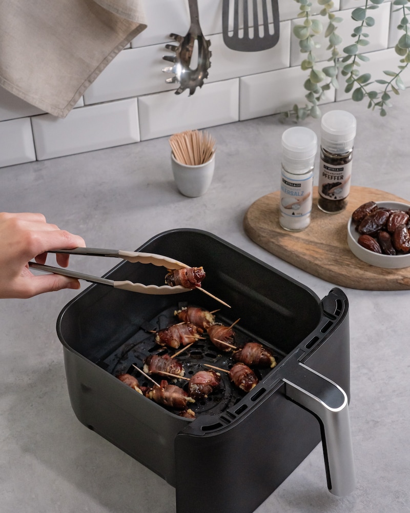 Dieses Bild zeigt wie die Datteln aus dem Airfryer genommen werden.